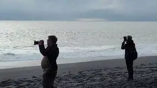Filming waves at the black sand beach near Vik, Iceland