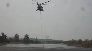 Вертолёт набирает воду для тушения пожара.