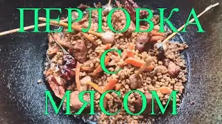 Barley porridge with pork in a cauldron over a fire. Barley pilaf 