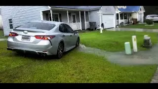 Cars driving over people's lawns to avoid flash flooding.
