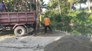 muat pasir menggunakan sekop