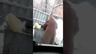 Пенсионерка роется в мусорном баке