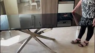 Tavolo da soggiorno Elegance. Allungabile con piana in Vetro Nero e Gambe incrociate in Acciaio