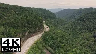 DRONE FOOTAGE VEHICLES TRAVELING ON A CURVY ROAD BESIDE THE MOUNTAIN (FREE STOCK VIDEO) 4K
