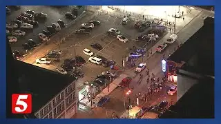 Shooter arrested after injuring two people in a parking lot near Broadway