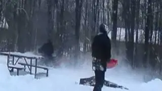 Sledding behind the snowmobile during snow storm
