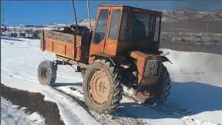 Трактор Т-16 буксует по в Снегу с Полный лафет Грузом
