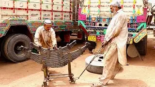 These mechanics are experts in fixing truck suspension systems (leaf springs)