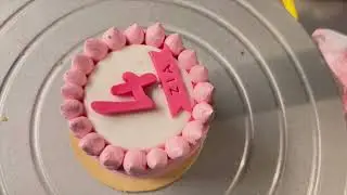 Piping a sharp dot border on this mini cake.