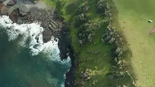 Полет дрона над крутым скалистым берегом моря