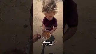Young child waits alone to receive food aid at a Gaza charity center 