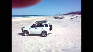 Suzuki Vitara pulling out a Prado and trailer on sand