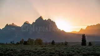 8K Stock Video - Time lapse of sun rays beaming from behind the Grand Teton Mountains