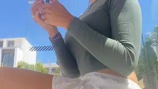 girl smoking  cigarette outside  on bus stop wearing a mini skirt