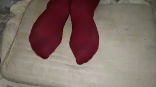 Girl dirty red socks trample and footrest on pillow