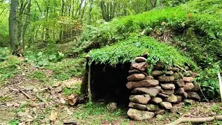 Building a hut with stone in the forest.building of a forest shelter in sunny weather