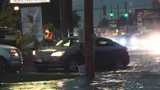 People Push Vehicle Out of Water as Torrential Rains Flood Parts of Illinois