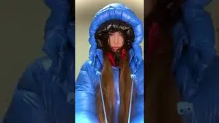 Girl in layers of puffers jackets and puffers hoods. Tightened layered hood similar to a spacesuit