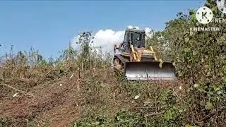 Bulldozer clearing down grass.in the mountian