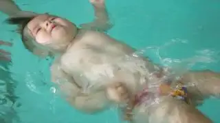 Малыш Алиса лежит на воде на спинке