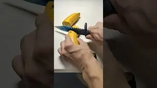 A cardboard knife cuts a banana.