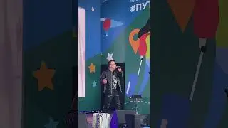 Мужик в очках поёт патриотические песни на сцене на территории ВДНХ