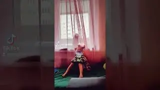 Маленькая черная кошка Снежок изподтишка охотится на ребенка.