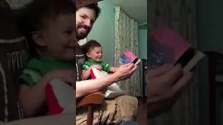 Baby Arthur laughing at a book of trains