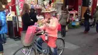 Man on a Bike eating Bread in Japan