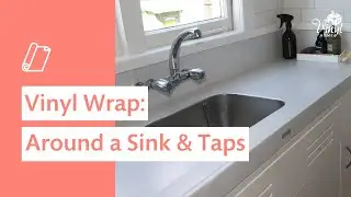 Applying self-adhesive vinyl around a kitchen sink and taps