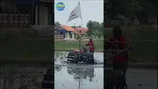 Traktor G1000 Boxer bajak sawah di pinggir perkampungan Karawang 