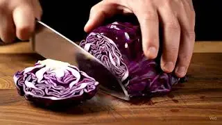 A highly realistic ASMR video of a hand slicing in great detail cabbage on a wooden cutting board.