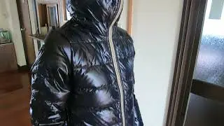 An elongated women's spacesuit down jacket with a fully fastened hood.