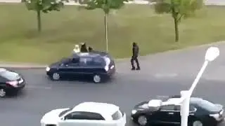 ОМОНовец стоит и бьёт проезжающие машины