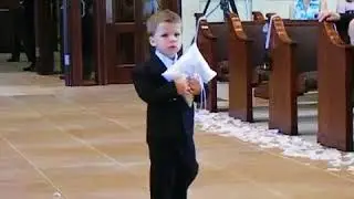 Le porteur de bagues avance lentement dans l'allée