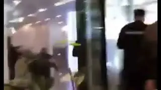 Люди стоящие в вестибюле бизнесцентра видимо не понимают что они на линии огня.