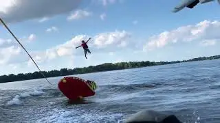 Kid ejected off tube behind surf boat slow motion