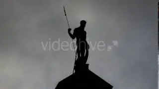 Zeus Looking Statue Standing on a Roof of a Medieval European City in Twilight
