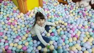 Karina plays with balls on the playground. Playground for children - balls and slides.