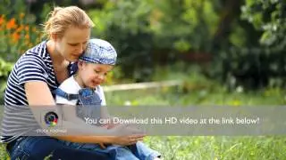 Boy playing with toy car sitting on moms lap outdoor