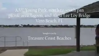 A W  Young Park north to south pan picnic area, lagoon, and Alma Lee Loy Bridge