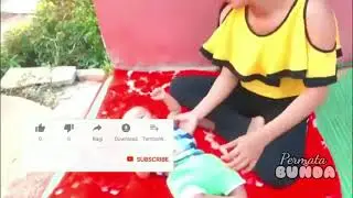 Ibu muda cantik menyusui sambil bermain bersama si kecil di pekarangan rumah