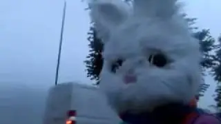 A giant rabbit stands on a bridge to wave to motorists
