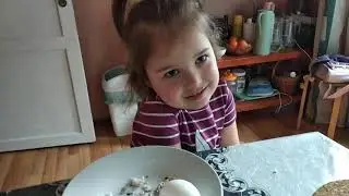 Ребенок ест яйцо со скорлупой.