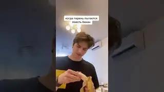 парень пытается поесть банан