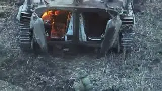 Russian troops hiding from a Ukrainian drone under a burning vehicle