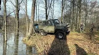 УАЗ вытаскивает трактор из реки.