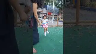Criança brincando no parquinho no balanço