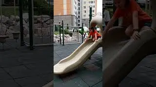 A small boy slides down a slide in the playground. #childhood #slide #sliding #slides
