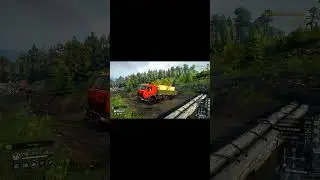КАМАЗ везет доски по болотистой местности 